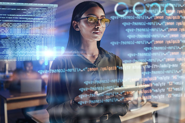 woman standing in front of a data display wearing yellow tinted eyeglass frames